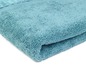 Une serviette en éponge pliée de couleur bleue.