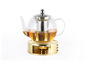 Théière en verre avec infuseur à thé sur un support doré avec une bougie chauffe-plat.