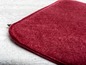 Un dessous-de-plat en tissu doux de couleur rouge foncé.