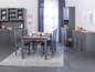 Une salle à manger avec une table, des chaises et un buffet gris avec des portes en verre