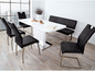Une table à manger blanche avec des chaises et un banc noirs