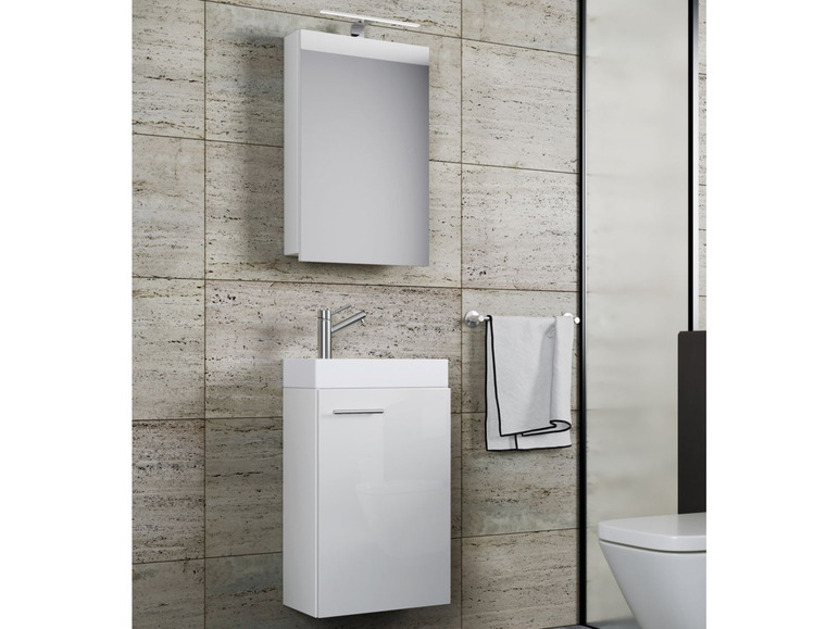 Meuble de salle de bain blanc avec miroir et lavabo.