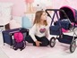 Une fille avec une poussette pour poupées, un lit pour poupées et un sac à dos à motif de coeurs.