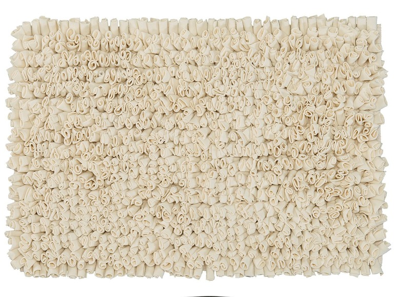 Un tapis de bain crème avec une surface douce et moelleuse.