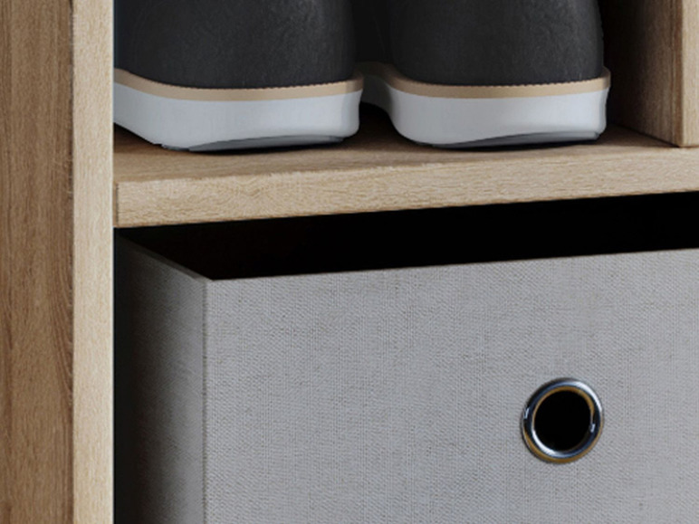 Une armoire en bois avec un tiroir et une paire de chaussures sur le dessus.