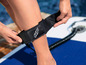 Gros plan d'une bande GHF noire autour d'une cheville sur un paddleboard.