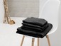 Une pile de serviettes noires sur une chaise blanche.