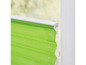 Un store plissé vert sur une fenêtre blanche.