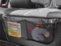 Une protection de siège auto grise avec des poches en filet pour les jouets et les livres.