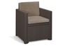 Un fauteuil de jardin en rotin marron avec des coussins beiges.