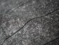Gros plan sur un tissu gris avec un motif subtil.