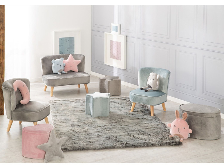 Deux fauteuils gris en velours, un fauteuil bleu, un pouf rose et gris et un pouf gris avec un coussin de lapin.