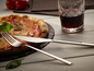 Une fourchette et un couteau Echtwerk avec une pizza et un verre de vin.