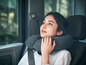 Une femme dans une voiture avec un coussin de voyage.
