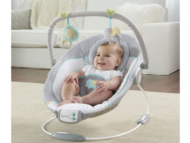 Un bébé dans un siège berçant Ingenuity sur le thème de l'éléphant.
