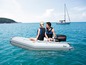 Un homme et une femme dans un bateau pneumatique avec un moteur hors-bord en mer.