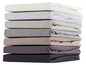 Une pile de draps de lit dans différentes couleurs.