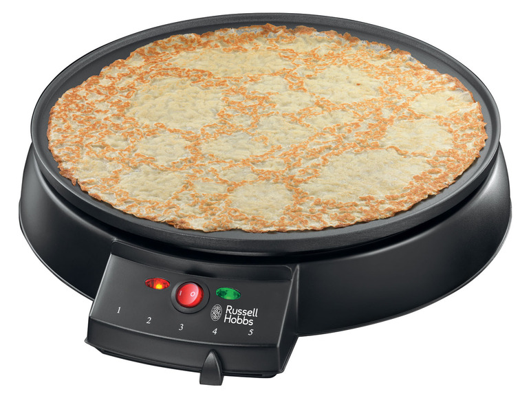 Une crêpe sur une crêpière noire Russell Hobbs.
