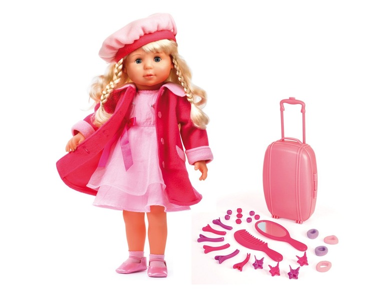Une poupée avec un manteau rose, une valise rose et des accessoires pour cheveux.