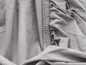 Gros plan d'un tissu extensible gris, adapté aux vêtements ou à la literie.