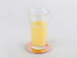 Un verre de jus d'orange sur un dessous-de-verre en cuivre.