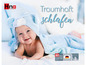 Un bébé dans une gigoteuse bleue avec le texte 'Traumhaft Schlafen' et la marque 'Hna Schlafsysteme'.