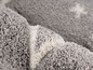 Un tapis gris et blanc avec une texture douce et pelucheuse.