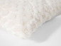 Un coussin en fourrure blanche.