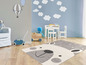 Une chambre d'enfant grise avec un chariot à jouets, une table de jeu et un tapis gris à motif d'ours.