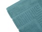 Détail d'un tapis de bain turquoise.