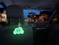 Un pendentif de voiture en forme de nuage vert avec un sourire à l'intérieur d'une voiture.