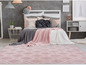 Un tapis rose avec un motif géométrique dans une chambre à coucher.