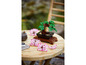 Un bonsaï LEGO avec des fleurs roses sur une table en bois.