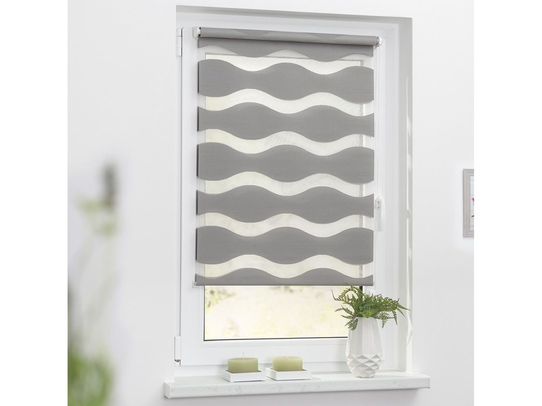 Un store enrouleur gris à motif ondulé pour une fenêtre.