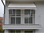 Un balcon blanc avec un auvent et une balustrade