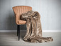 Une couverture marron sur un fauteuil en cuir