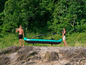 Un homme et une femme portent un kayak gonflable de la marque HF.