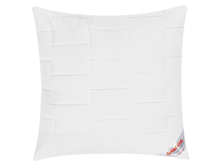 Un oreiller blanc matelassé avec la marque Schlaf-Gut.