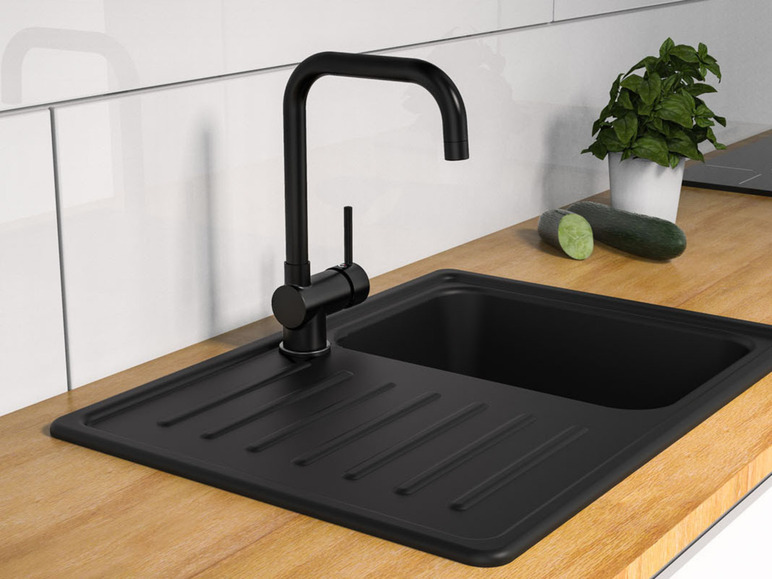 Un évier noir avec un robinet noir dans une cuisine moderne.