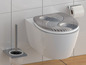 Une toilette avec un siège de toilette gris au design zen.
