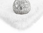 Un tapis blanc et moelleux avec une boule de verre dessus.