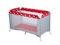 Un parc pour bébé gris avec des draps rouge et blanc de la marque Safety 1st.