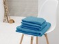 Une pile de serviettes bleues sur une chaise blanche.