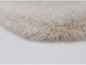 Gros plan sur un tapis en fourrure beige et moelleux.