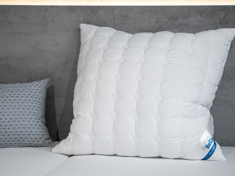 Un oreiller blanc matelassé de la marque Beco sur un lit.