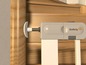 Une barrière de sécurité blanche avec une fermeture Safety 1st, fixée à un montant de porte en bois.