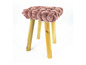 Tabouret rose avec assise tressée et pieds en bois.