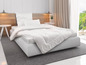 Une couette et un oreiller blancs sur un lit avec une tête de lit blanche.