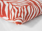 Un coussin avec un motif zèbre en rouge et blanc.