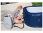 Une femme gonfle une baignoire gonflable avec une pompe électrique.